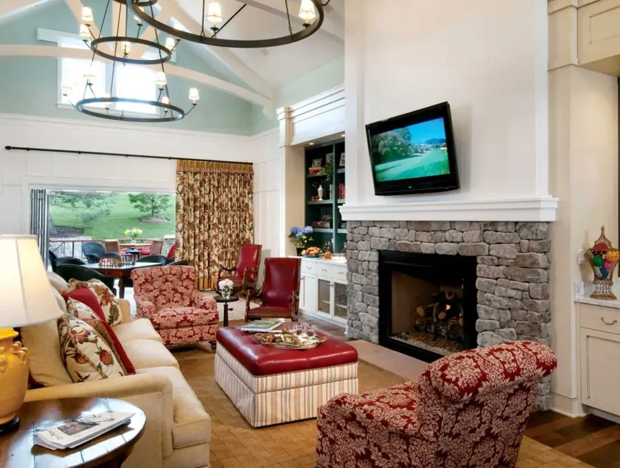 Living room of a Colorado cottage with a fireplace and printed drapes.