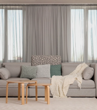 Grey-toned living room with a grey custom drapery system in the background.