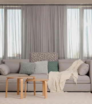 Skyco Drapery Systems 5 Grey-toned living room with a grey custom drapery system in the background.