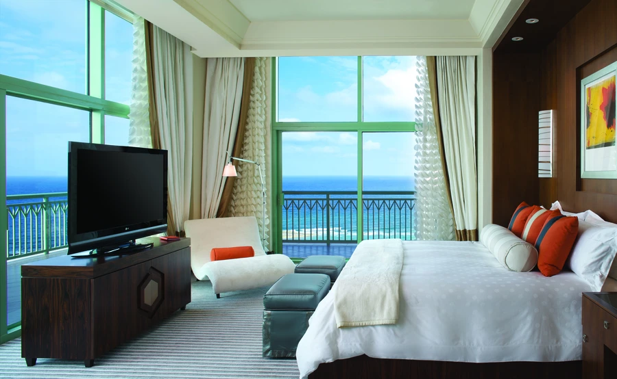 Bedroom with floor-to-ceiling windows – drapes custom-built by Skyco.