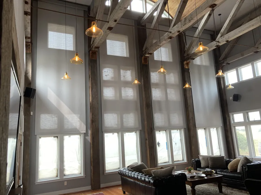 Large living room with floor-to-ceiling windows and custom roller shades.