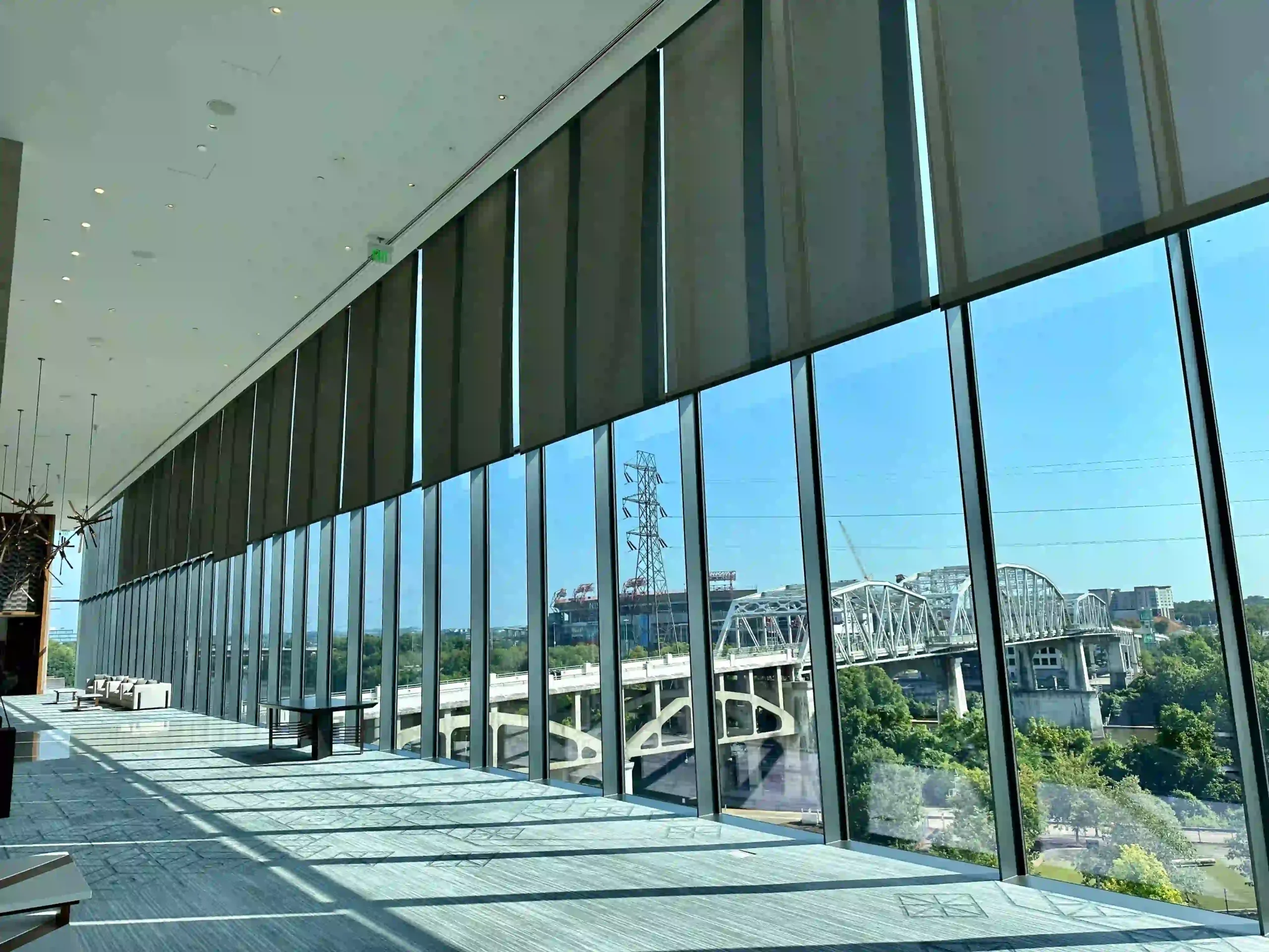 Hotel in Nashville with custom roller shades, rolled halfway up, on full-length windows.