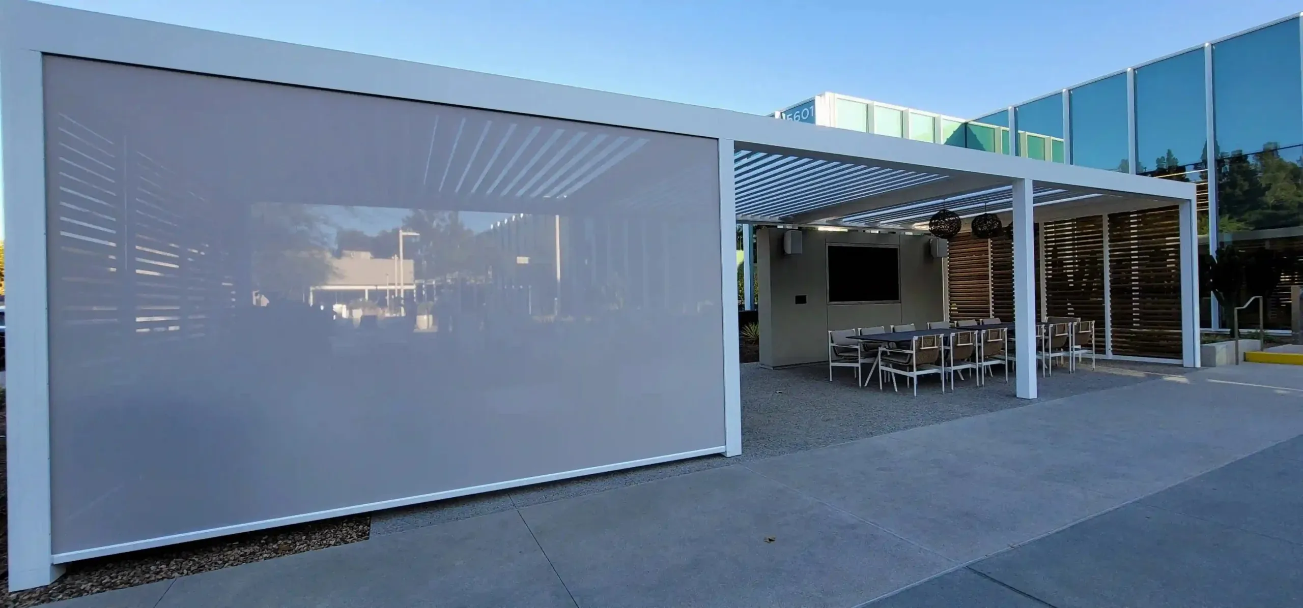 Outdoor dining area with custom roller shades from Skyco.