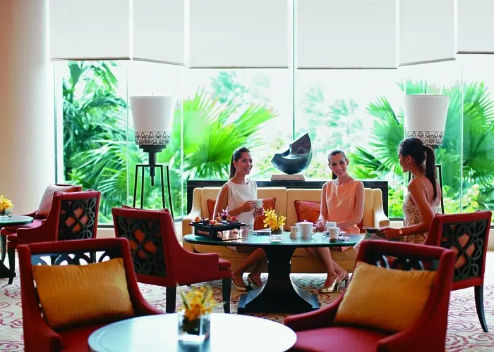 Three women sit in the dining room of an upscale hotel.