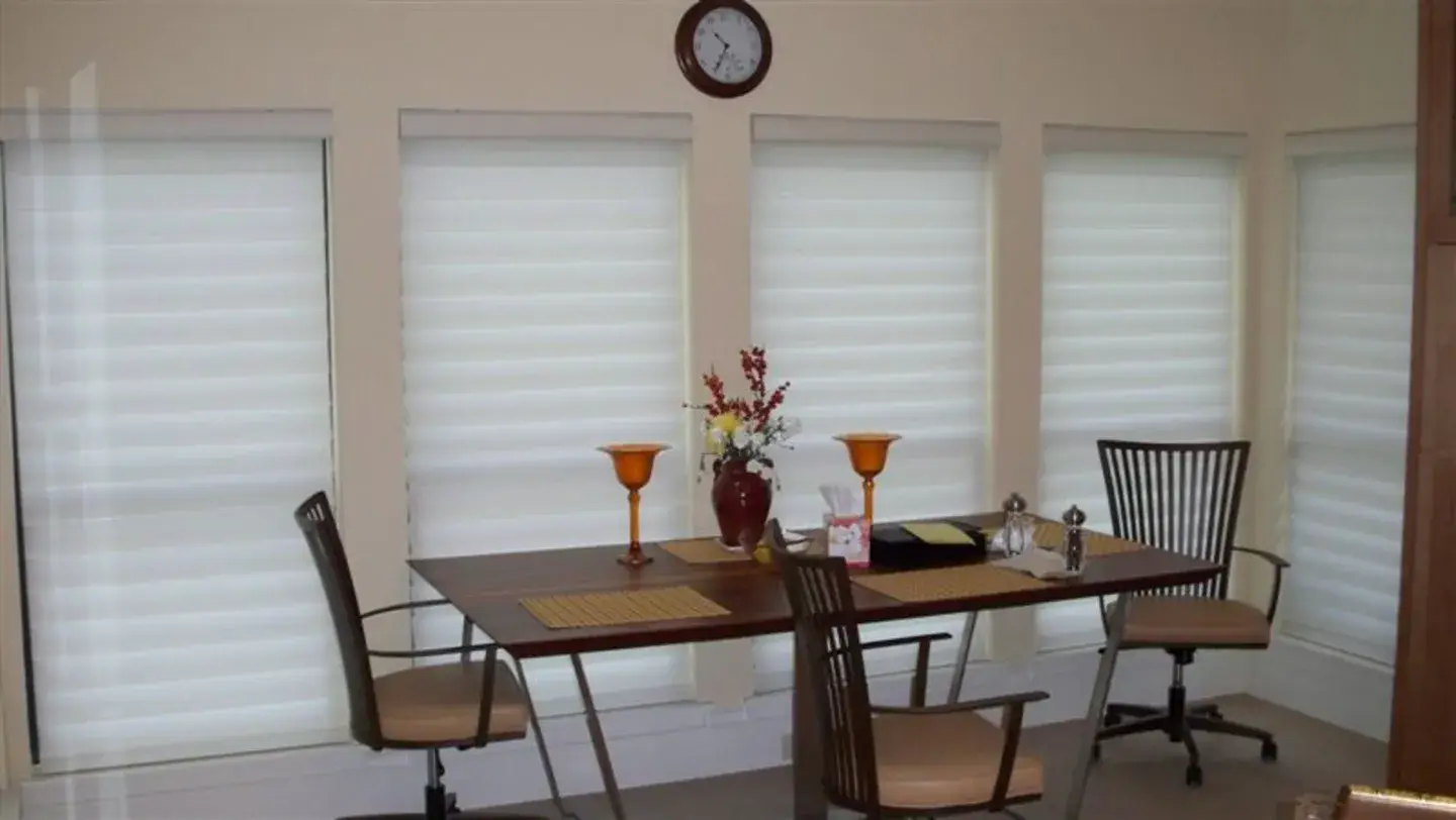 Dining room with custom Roman shades, designed and built by Skyco.