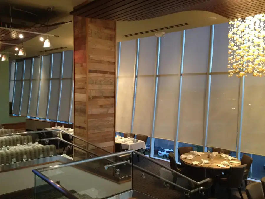 Angled roller shades, custom designed to add ambiance and privacy to a restaurant.