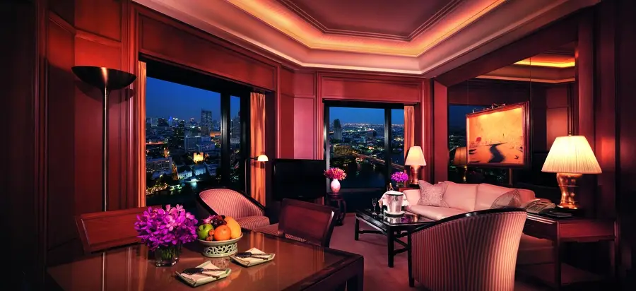 Low-lit room of a hotel in Bangkok. Custom drapes adorn the windows.