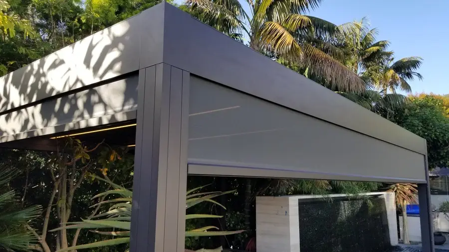 Mostly raised exterior roller shade attached to a custom shading structure.