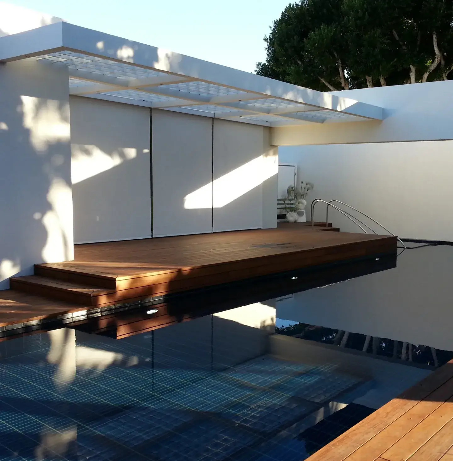 Custom exterior roller shades covering a pool outside of a modern cabana.