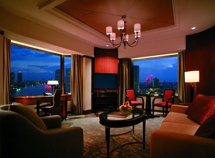 Living room of a hotel suite with large windows. Custom drapes cover them.
