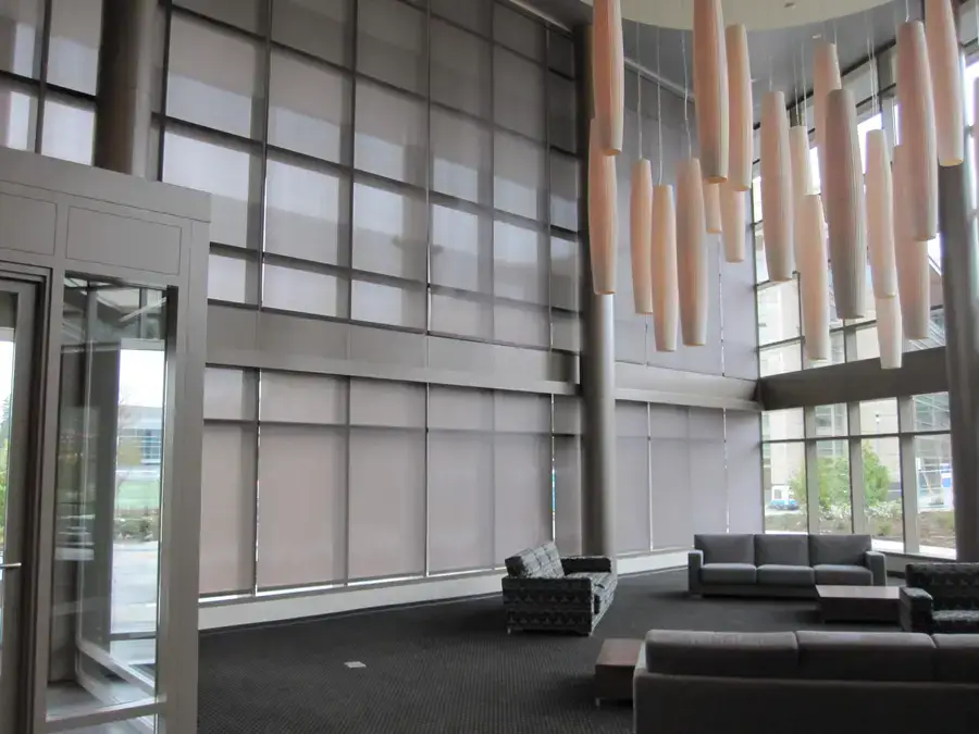 Lobby of a large office space with custom roller shades on the windows.