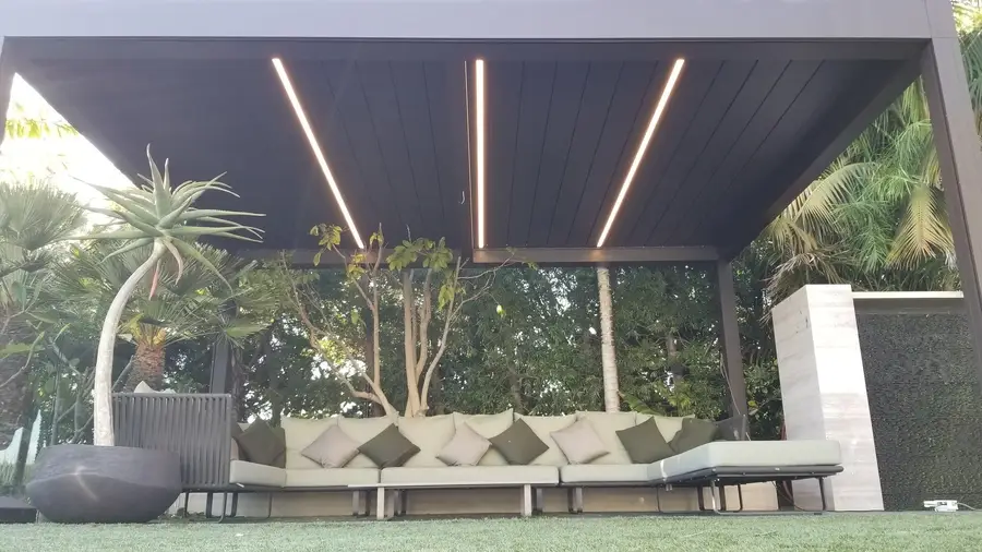 Set of outdoor patio furniture under a custom shading structure, built by Skyco.